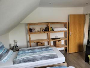 um quarto com uma cama e uma estante de livros em Gästezimmer em Springe