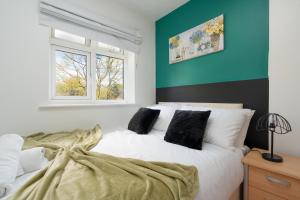 1 dormitorio con 1 cama blanca grande con almohadas en Chique Manchester Abode - Parking - 8mins to City, en Mánchester