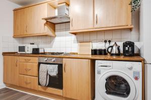 a kitchen with a washer and a washing machine at Chique Manchester Abode - Parking - 8mins to City in Manchester