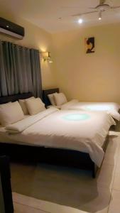 Un dormitorio con una cama grande con luz. en The Elet Business Hotel en Karachi