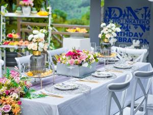 Una mesa blanca con flores en jarrones. en Magoebaskloof Mountain Lodge, en Tzaneen