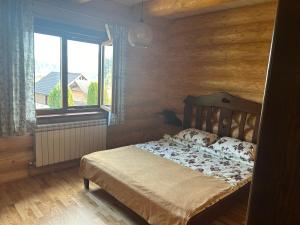 Un dormitorio con una cama con una pared de madera. en Karpaty, en Yaremche 68 fotos más