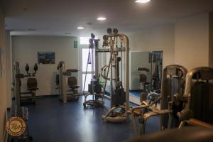 a gym with several treadmills and machines in a room at Pleskini Apartment in Sankt Englmar