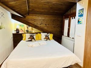 a bedroom with a white bed with a wooden ceiling at Apartament Immovall in Durro