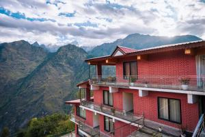 ジョシマットにあるAaryam Resort, Auliの山を背景にした赤い建物