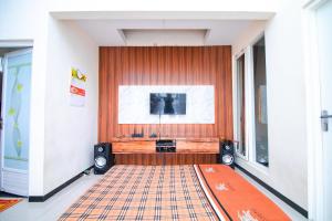 a living room with a television and a rug at Villa Azzalia Syariah Private Pool and Karaoke in Tlekung