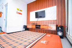 a bedroom with a bed with a tv and speakers at Villa Azzalia Syariah Private Pool and Karaoke in Tlekung