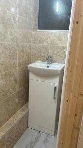 a bathroom with a white sink and a mirror at Home Away in a Close in Thamesmead