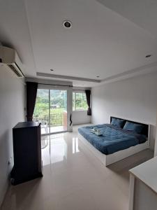 ein Schlafzimmer mit einem blauen Bett und einem großen Fenster in der Unterkunft TG Apartment Aonang in Ao Nang Beach