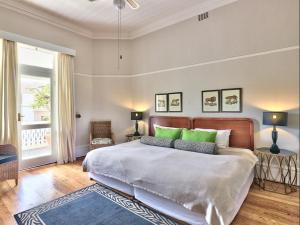 a bedroom with a large bed with green pillows at The Cape Colonial Guest House in Cape Town