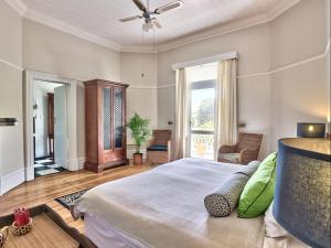 a bedroom with a large bed with a ceiling fan at The Cape Colonial Guest House in Cape Town