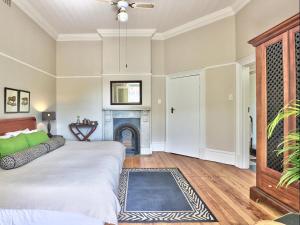 a bedroom with a bed and a fireplace at The Cape Colonial Guest House in Cape Town