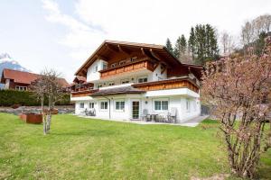 een groot wit huis met een grote tuin bij Carbonare Helene in Sankt Gallenkirch