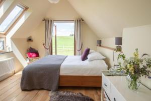 a bedroom with a bed and a large window at Little Wren in Holbeton