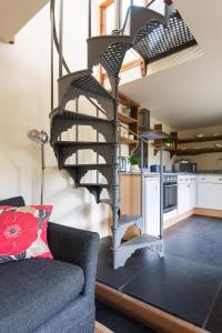 escalera de caracol en una sala de estar con sofá en Little Wren, en Holbeton