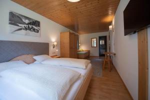 a bedroom with a large bed and a living room at Carbonare Helene in Sankt Gallenkirch