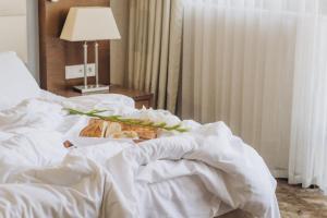 Una cama con una cesta de pan y una lámpara en Costé Hotel, en Tiflis