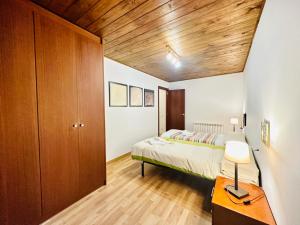 ein Schlafzimmer mit einem Bett und einer Holzdecke in der Unterkunft BA12 IMMOVALL BARRUERA in Barruera