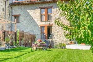 una casa de ladrillo con un patio delante de ella en Acogedora casa rural con jardín y barbacoa próxima a Pamplona, en Ilzarbe