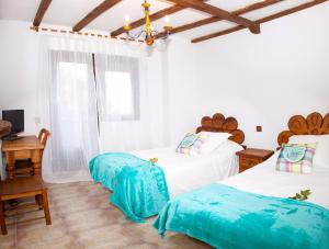 a bedroom with two twin beds with blue sheets at Alojamiento Rural Villanueva del Conde in Villanueva del Conde