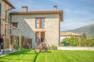 una casa de piedra con un patio delante en Acogedora casa rural con jardín y barbacoa próxima a Pamplona, en Ilzarbe