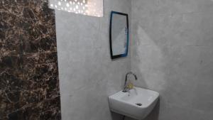 łazienka z umywalką i lustrem na ścianie w obiekcie Vishnu Niwas Homestay - Weekend Holiday Home w mieście Abu