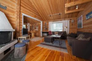 a living room with wooden walls and a fireplace at Hukka, 4+3 hlö, Levi in Levi