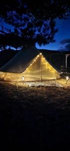 Tienda iluminada en un campo por la noche en Tente Lodge TIPI A 1H de Nice CLAIR DE LUNE en Bézaudun-les-Alpes