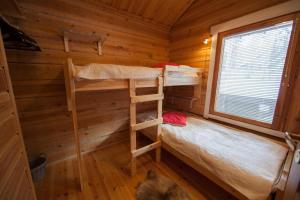 a bedroom with two bunk beds in a log cabin at Hukka, 4+3 hlö, Levi in Levi