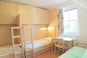 A bed or beds in a room at Jugendgästehaus St. Gilgen