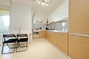 una cucina con due sedie e un tavolo di Bilocale con vista sull'aeroporto - comodo per il viaggio a Fiumicino Altre 32 foto