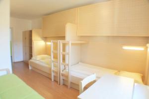 a bedroom with a bunk bed with a desk and a table at Jugendgästehaus St. Gilgen in Sankt Gilgen