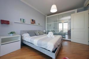 una camera da letto con un grande letto con lenzuola bianche e una finestra di Bilocale con vista sull'aeroporto - comodo per il viaggio a Fiumicino