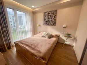 Schlafzimmer mit einem Bett und einem Fenster in der Unterkunft Naujas 2 kambarių butas in Vilnius