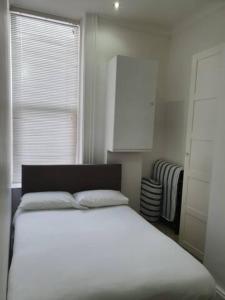 a bedroom with a white bed and a window at Northcliffe Sea View in Sunderland