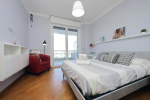 una camera da letto con un letto grande e una sedia rossa di Bilocale con vista sull'aeroporto - comodo per il viaggio a Fiumicino