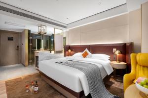 1 dormitorio con 1 cama blanca grande y 1 silla amarilla en 宜尚Plus酒店广州北京路步行街店, en Guangzhou