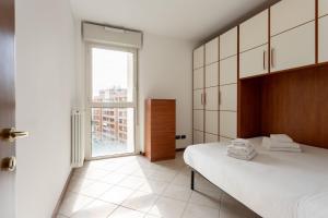 1 dormitorio con cama y ventana grande en Futurismo, en Milán