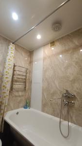 a bathroom with a tub and a shower with a shower at Аренда квартиры посуточно in Cherkasy