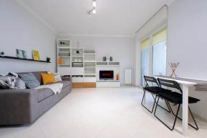 a living room with a couch and a table at Lusso Con Vista - Elegante e Luminoso con Self Check-in, Vicino All'Aeroporto in Fiumicino