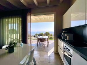 cocina con vistas a una mesa con sillas en La Giolosa Gardapartments, en Moniga del Garda