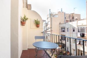 een blauwe tafel op een balkon met gebouwen bij Gracia12 in Barcelona