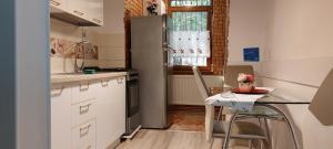 Il comprend une cuisine équipée d'un réfrigérateur et d'une table avec une chaise. dans l'établissement Apartament Maria, à Galaţi