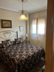 Un dormitorio con una cama grande y una lámpara de araña. en Villa Rafael, en Puente del Obispo