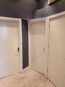 two white garage doors in a room with a black wall at Northcliffe Sea View in Sunderland