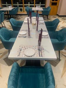 a long table with blue chairs and plates on it at Green valley boutique in Paro