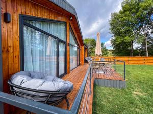 a wooden deck with chairs and a table and a umbrella at Moon Village Comarnic in Sinaia