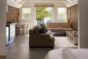 a living room with a couch and a table and a kitchen at Myrtle Loft in Cape Town