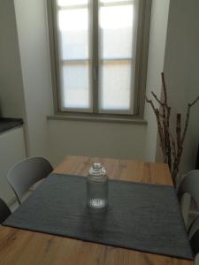 uma mesa de madeira com um frasco de vidro em cima em Historic center lake Como Bellano modern studio em Bellano