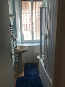 a small bathroom with a sink and a window at La Cascade appartement F2 in Eaux-Bonnes +9 photos